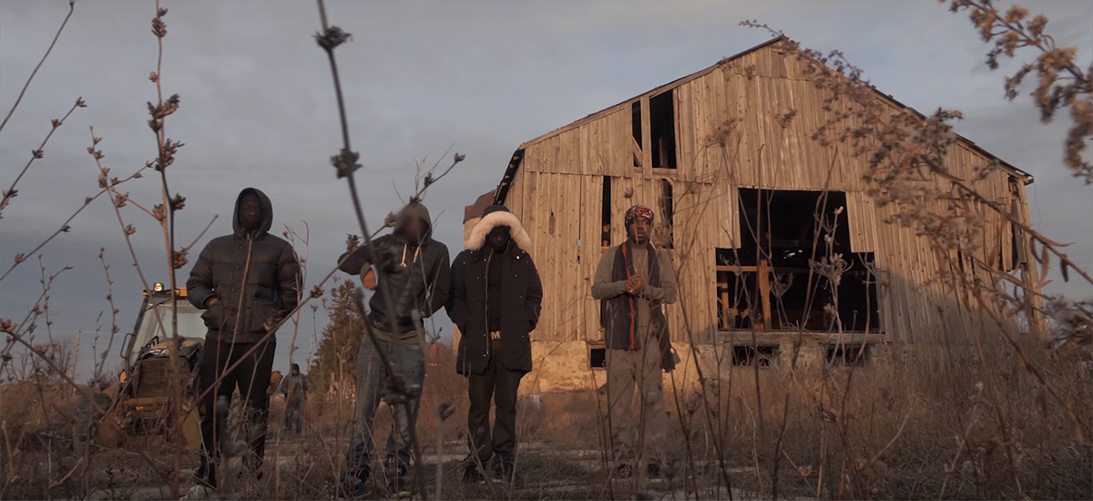 Burna Bandz and his crew outside of an abandoned barn in the Beast Mode video.