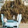 A scene from the new Burna Bandz video for CROS. Burna can be seen rapping his verse next to a luxury car.
