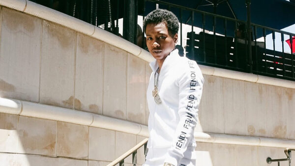 Photo of Toronto rapper Pressa wearing a Fendi suit and some chains around his neck.