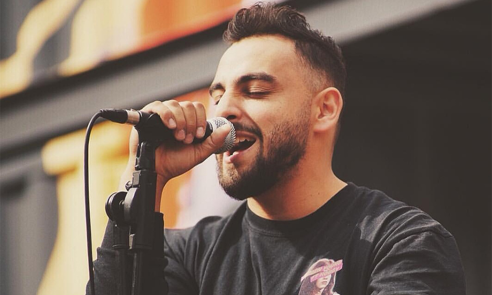 A photo of Calgary-singer Ruben Young holding a microphone and performing