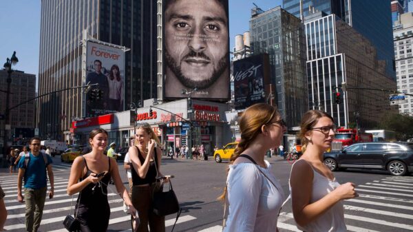 Nike ad in New York in 2018, showing former San Francisco 49ers quarterback Colin Kaepernick after his 2016 kneeling protest. Could a corporation sell an act like Kaepernick's 'kneel' as an NFT? (AP Photo/Mark Lennihan)