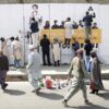 Residents in Kabul, Afghanistan walk past artists from the ArtLords organization as they paint a mural of journalists who were killed in 2018. (AP Photo/Massoud Hossaini)