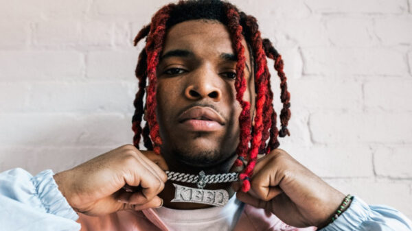 Atlanta rapper Lil Keed holds up the YSL chain he has on