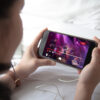 An over-the-shoulder view of someone streaming a concert on a mobile device