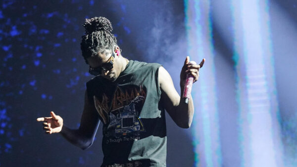 Young Thug holds a microphone while performing in Austin, Texas