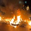In Tehran, Iran, a police motorcycle burns during a protest over the death of a young woman
