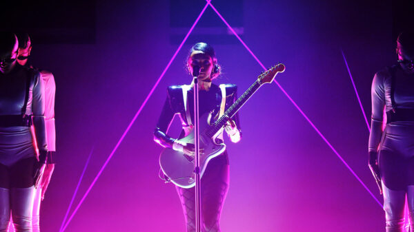 Janelle Monáe holds a guitar on stage during the 2019 Grammys