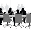 Silhouette of businesspeople sitting at a boardroom table