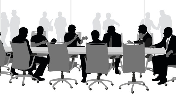 Silhouette of businesspeople sitting at a boardroom table