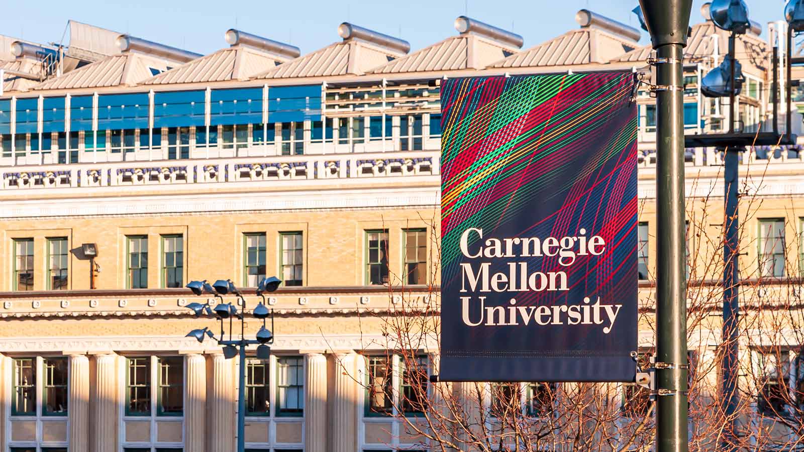 A flag with the text 'Carnegie Mellon University' is seen on the flag hanging in front of a building.