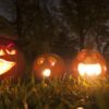 Four carved halloween pumpkins with lit candles