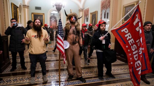 Armed protestors stand in the US Capitol on 6 January 2021