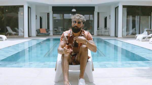 A man sits on a chair by a pool