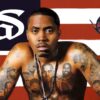 Nas sits in front of an U.S. flag with the stars of the flag replaced by the Nas logo