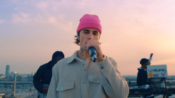 Justin Bieber in a pink toque holding a microphone