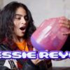 A woman holding a toy and the words 'Jessie Reyez' at the bottom of the image.