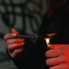 Close-up shot of a person lighting silver spoon