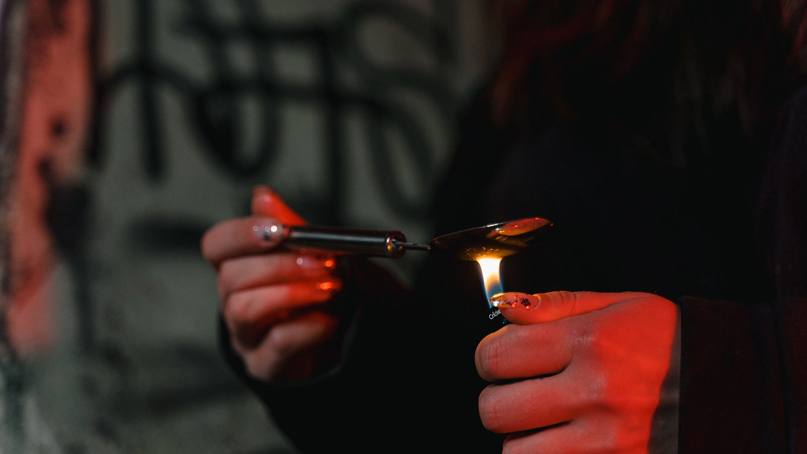 Close-up shot of a person lighting silver spoon