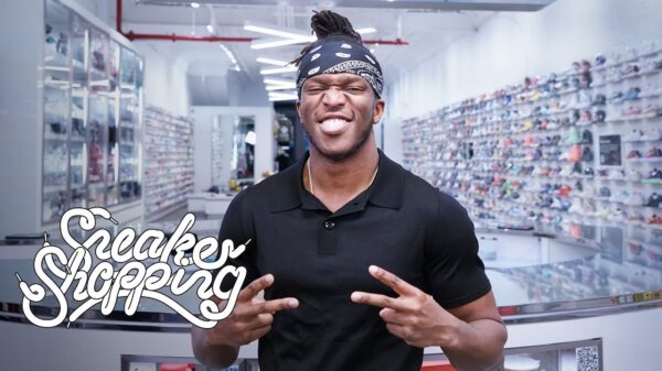 UK rapper KSI holds up two peace signs while posing for a picture in a sneaker store.
