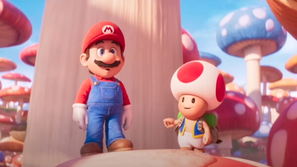 Super Mario and Toad standing next to each other in a scene from the new feature film, The Super Mario Bros. Movie.