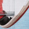 A painter on a Aerial Lift Platform paints an image of a shoe