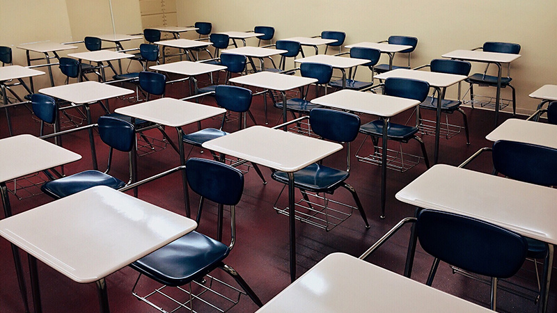 An empty classroom with several empty desks