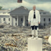 Tom MacDonald stands on a broken pillar amongst a pile of rubble
