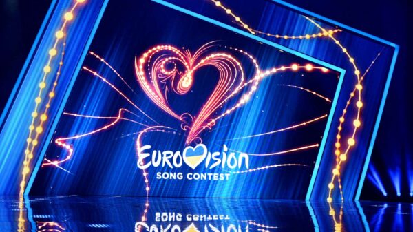 The Eurovision performance stage with the competition's logo visible in the background.