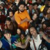 Rappers J. Cole and Lil Durk stand amongst a large group of young people in their music video for All My Life