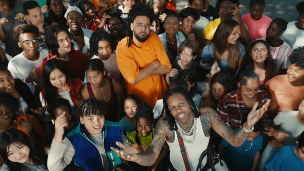 Rappers J. Cole and Lil Durk stand amongst a large group of young people in their music video for All My Life