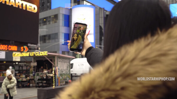 A woman takes a selfie video in Time Square