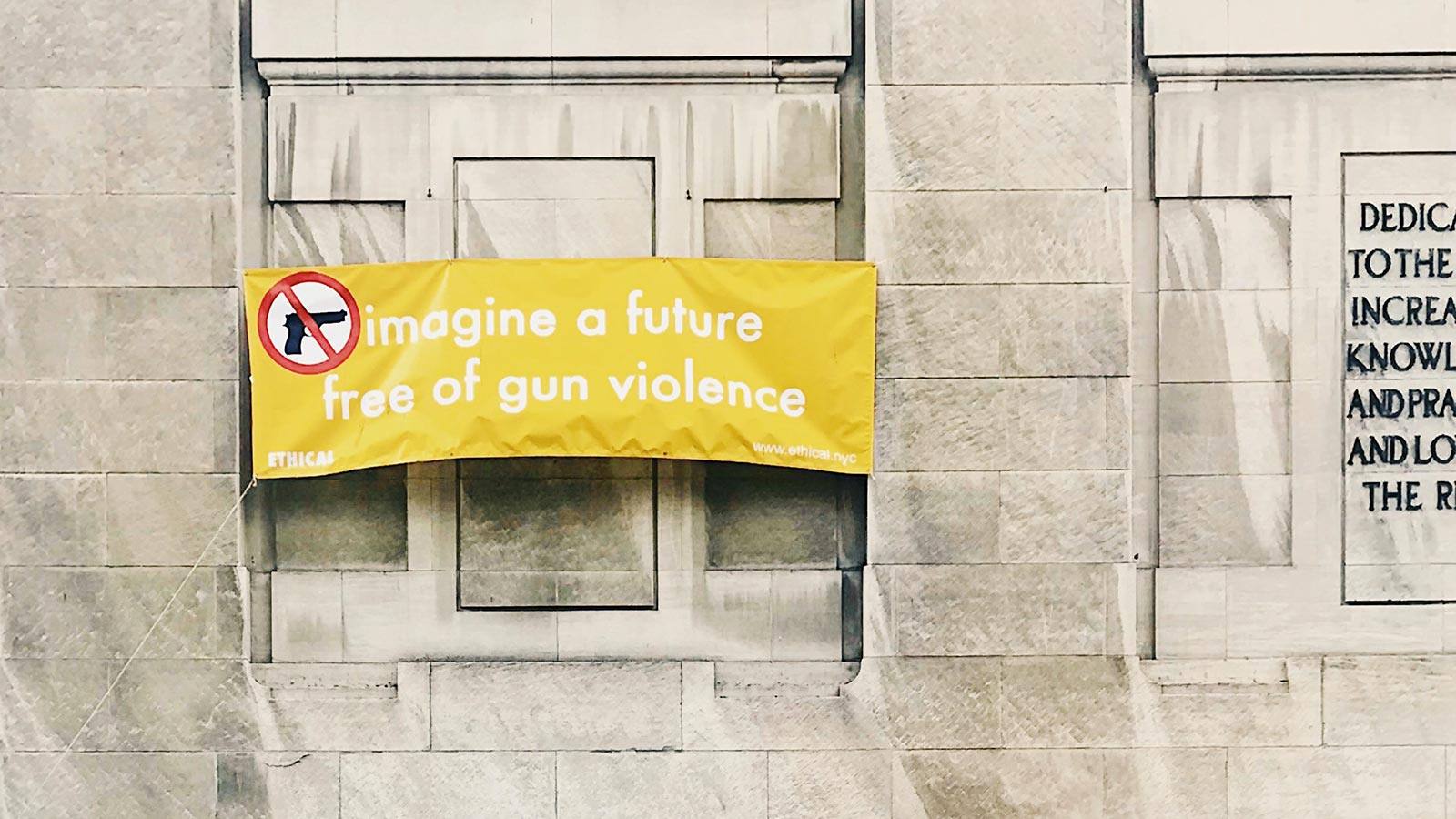 A banner hung on a building which contains the text: 'Imagine a future without gun violence.'