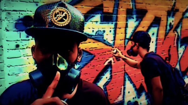 A man spray paints graffiti on the wall in a scene from the Shob Chup music video by Skibkhan