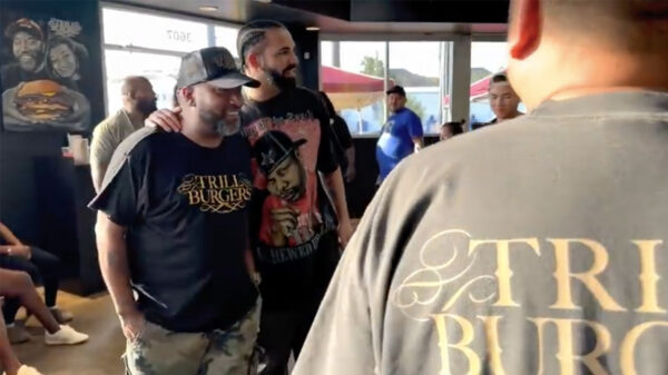 Rappers Drake and Bun B posing for a photo inside a Trill Burgers location