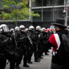 A row of riot police face off against protestors in Montréal.