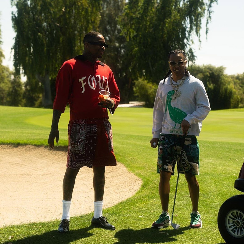 Two men stand on a golf course during the Unfollow Me videoshoot.