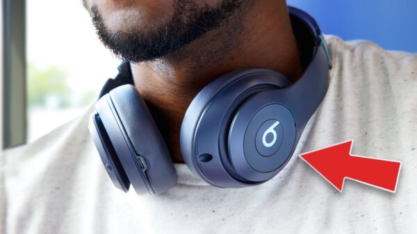A red arrow points at a pair of the new Beats by Dre headphones around a man's neck