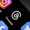 The icon for the Threads next, sitting next to other social media app icons on a mobile device.