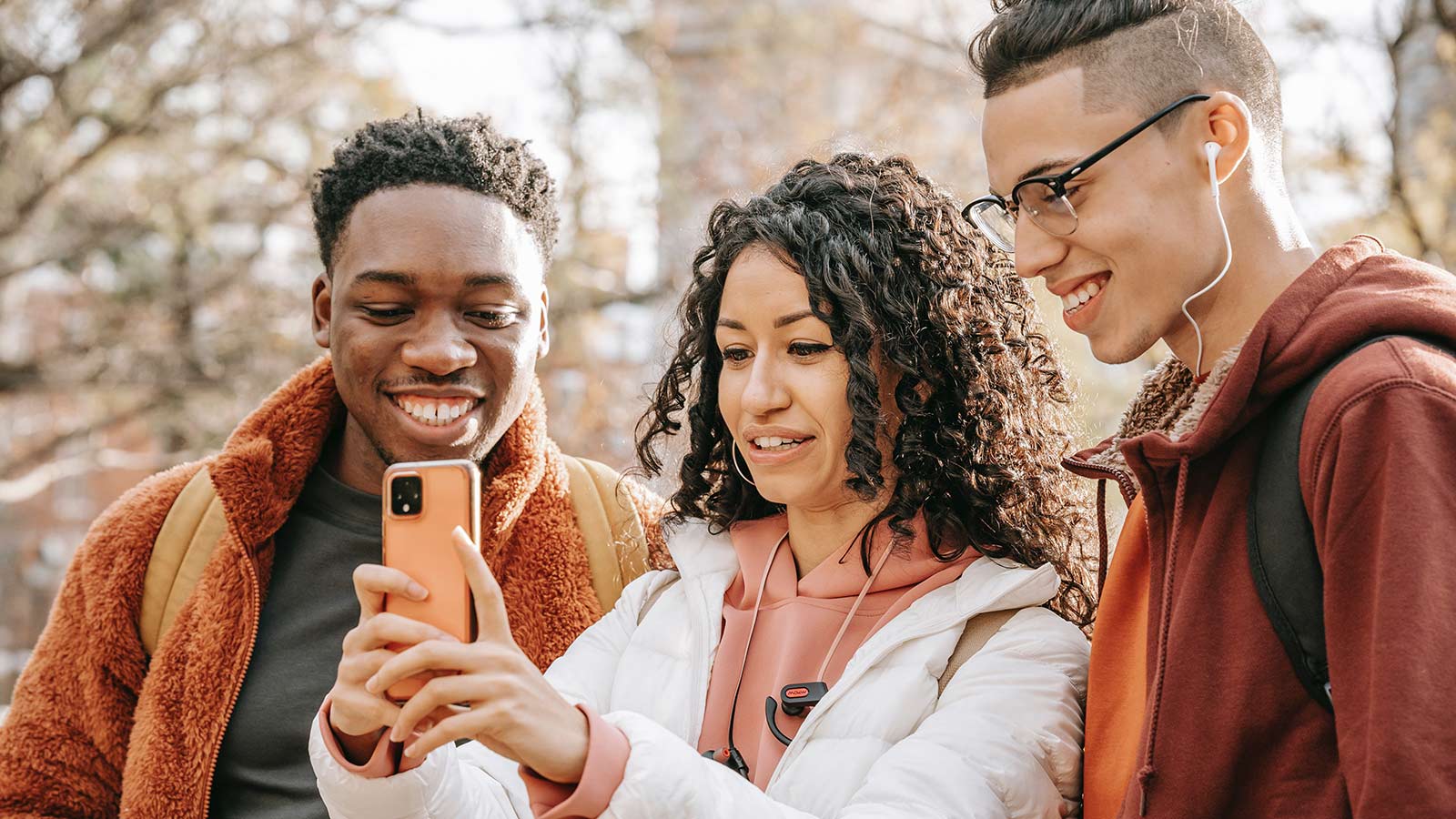 Smiling diverse friends taking a selfie on smartphone.