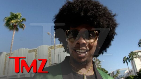 Recording artist Trinidad James looks into the camera close up with a palm tree visible in the distance.