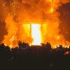 A large crowd stands before a fire at the Burning Man festival