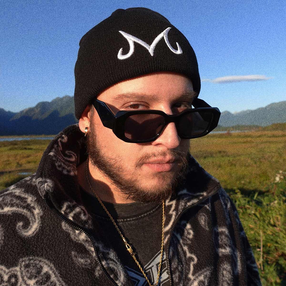 An outdoor selfie of a man in a toque and sunglasses