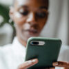 A Black woman messaging on modern cellphone