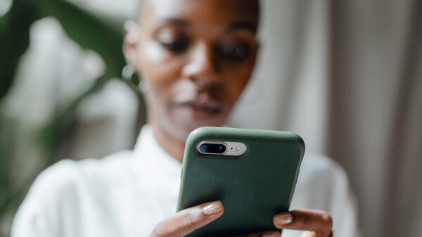 A Black woman messaging on modern cellphone