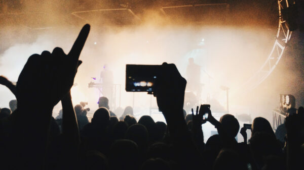 Silhouette of people taking photos from the crowd at a rock concert