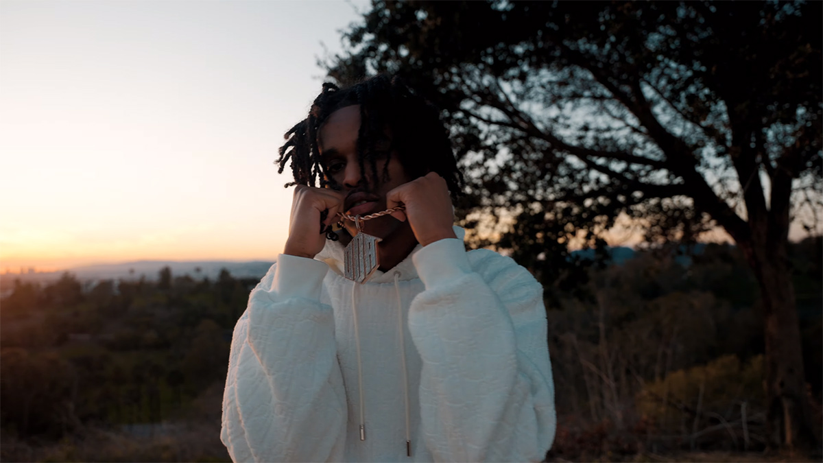 TwoTiime holds up his chain in the 4U video in and outside of Los Angeles.