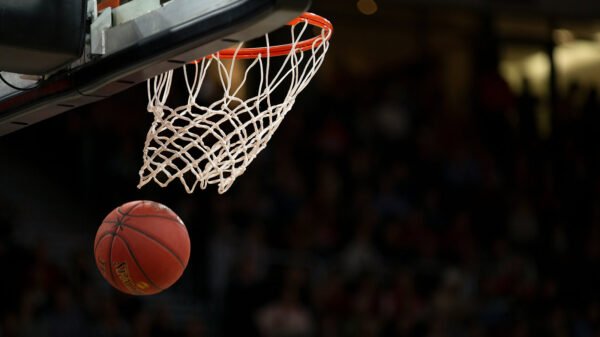 A basketball going through a basketball net after being shot.
