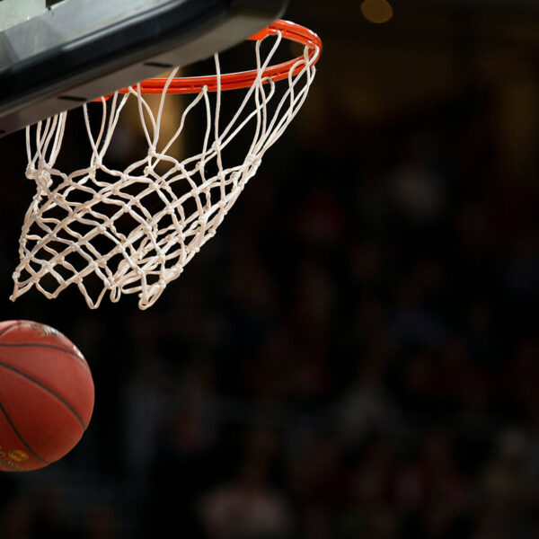 A basketball going through a basketball net after being shot.
