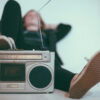 A man relaxing with his foot on a boombox.