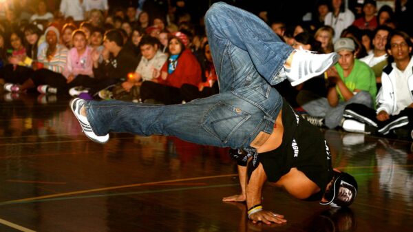 A breakdancing event with a breakdancer in the middle of a circle of people.